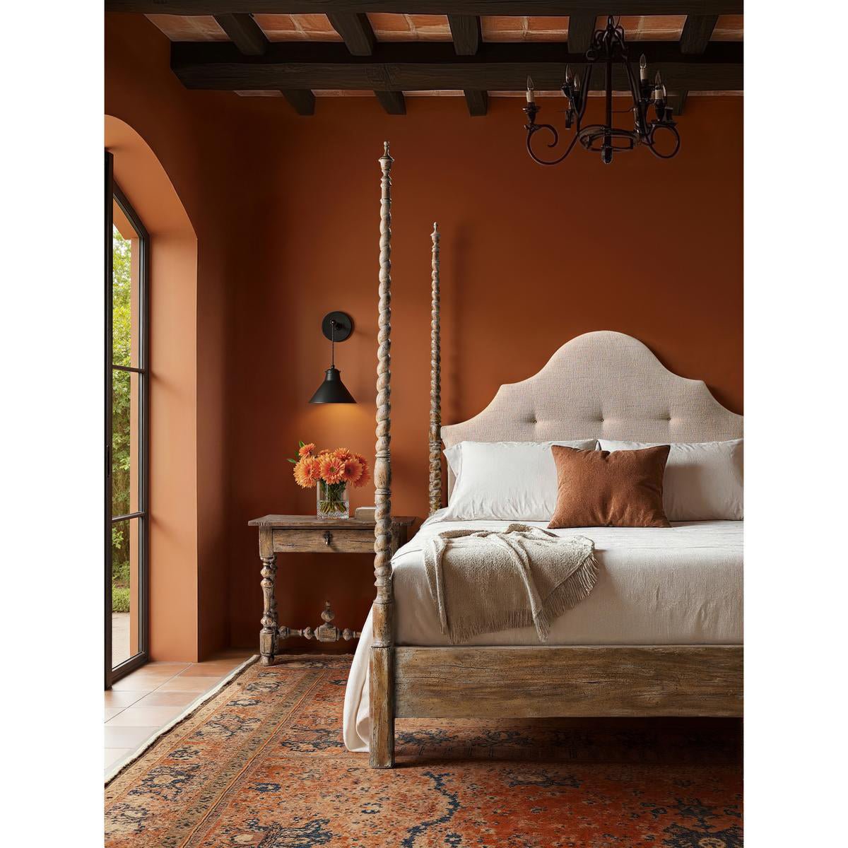 Rustic poster bed in warm-toned bedroom, side view.